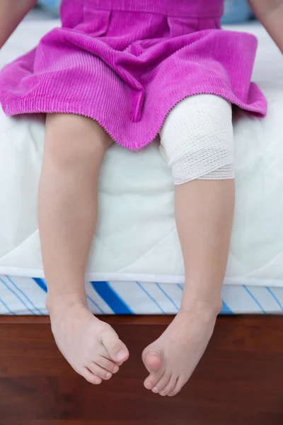 Child injured. Wound on the child\'s knee with bandage.