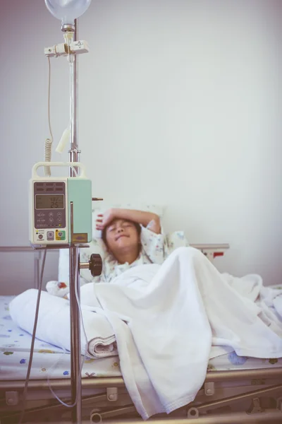 Asian boy sleeping on sickbed with infusion pump intravenous IV drip.