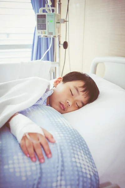 Asian boy lying on sickbed with saline intravenous (IV). Health care and people concept.