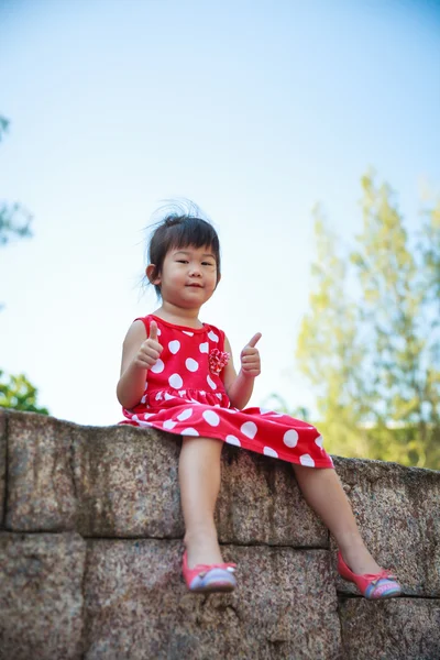 Happy asian girl with thump up and relaxing outdoors in the daytime