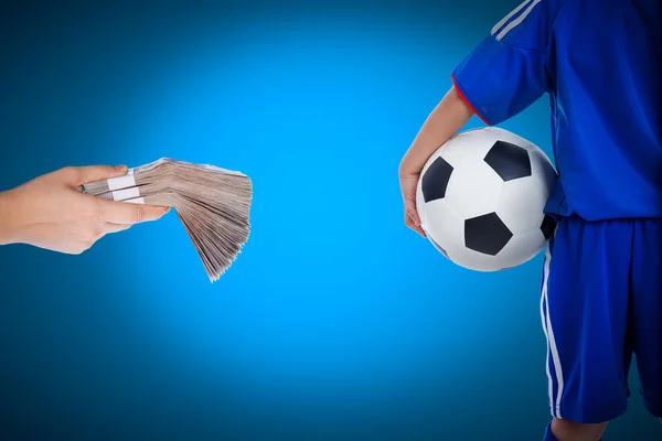 Back view of youth soccer player and hand holding stacks of bank