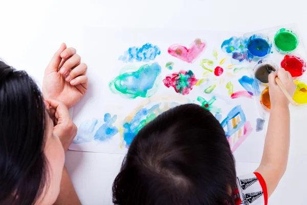 Asian girl painting and using drawing instruments, studio shot.