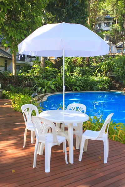 White plastic garden furniture table and chairs summer evening -