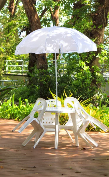 White plastic garden furniture table and chairs summer evening -