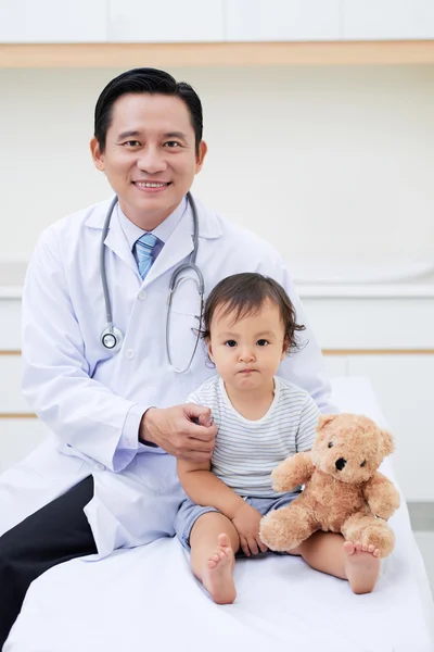 Vietnamese doctor hugging little baby