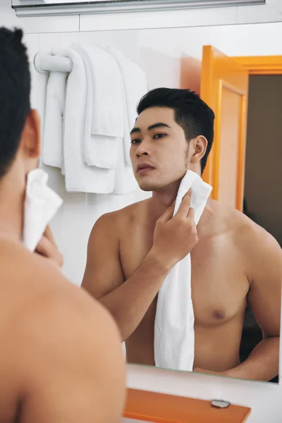 Man wiping skin after shaving