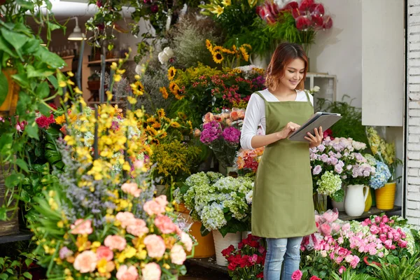 Flower shop owner working on tablet