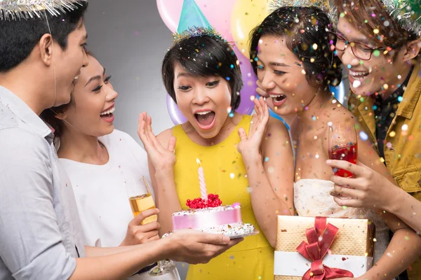 Friends presenting a birthday cake