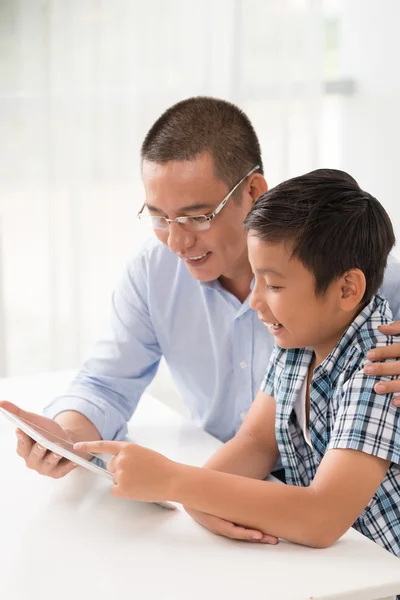 Father and son using digital tablet