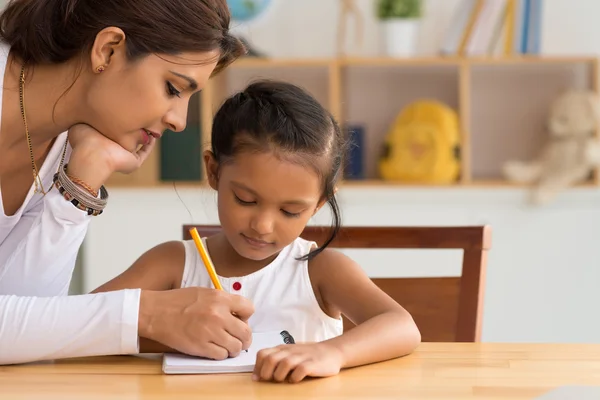 Woman helping daughter with homework