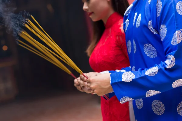 Man and woman holding incense sticks