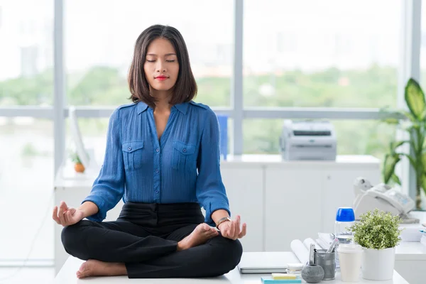 Businesswoman meditating in office