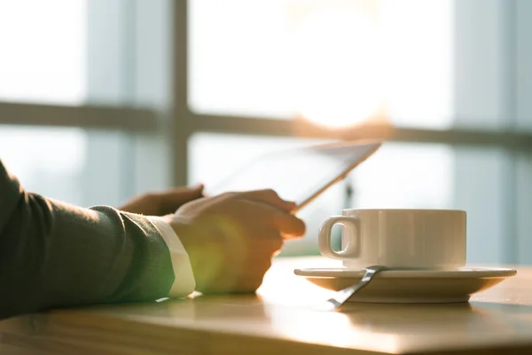 Person drinking coffee and reading news