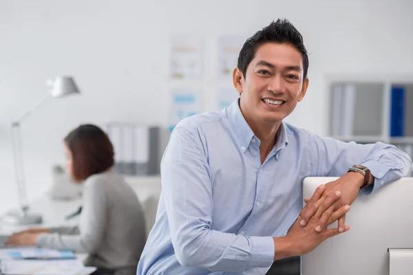 Businessman leaning on the computer monitor