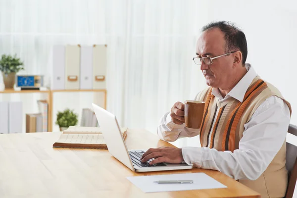 Mature businessman checking e-mail on laptop