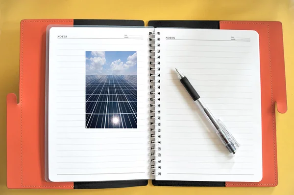 Business plane notepad with solar cell photo on table