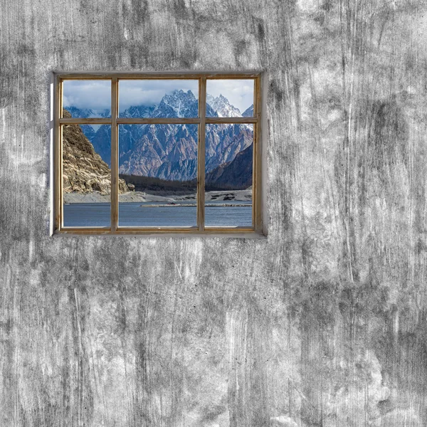Windows frame on cement wall and view of Hunza valley, Pakistan