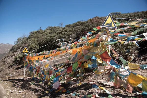 Sign road on the mountain with prayer flags