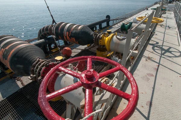 Oil tanker is transferring oil to the cargo vessel