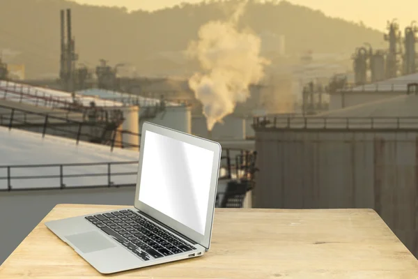 Laptop on wood table with oil tank