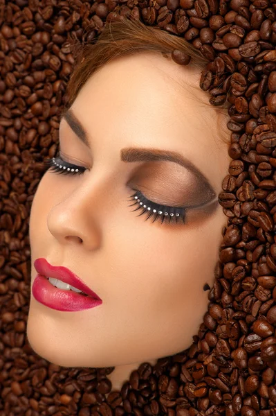 Beauty face with bright makeup in coffee beans