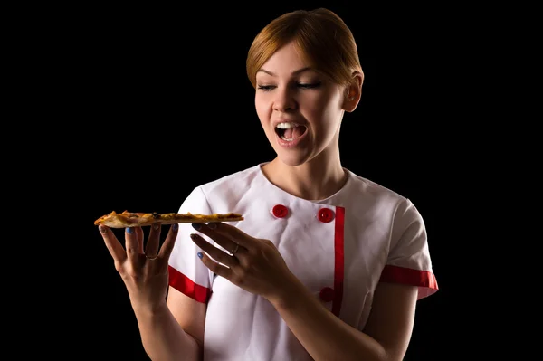 Young chef eating a slice of pizza