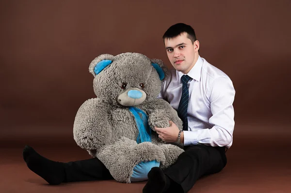 Young businessman hugging a teddy bear