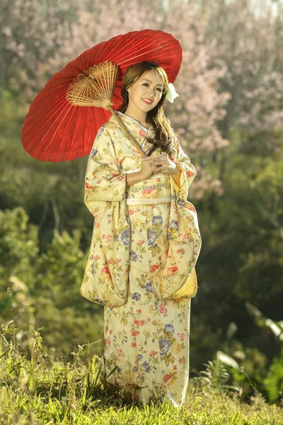 Asian women wearing traditional japanese kimono and red umbrella