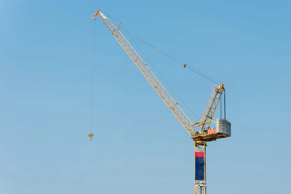 Industrial construction cranes at construction site with blue sky background