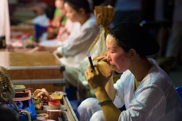 A Chinese opera actress painting mask on her face before the performance at backstage at major shrine in Bangkok's chinatown on October 16, 2015 in Bangkok,Thailand