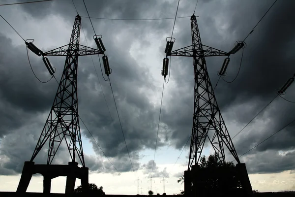 Pillars of line power electricity on gray storm clouds