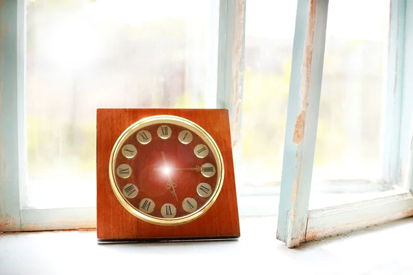 Vintage wooden clock at old rural window, concept past time