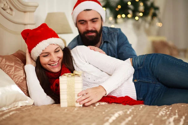 Man presents girl New Year\'s gift, Christmas couple in bed