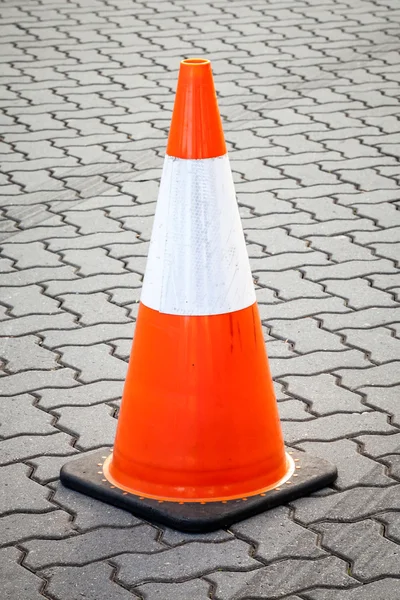 Orange and White Movable Traffic Cone on Paved Street