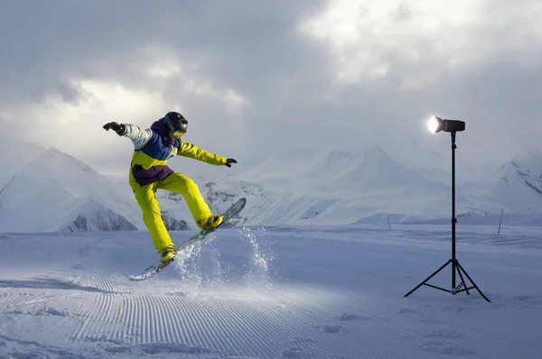 Photoshoot snowboarder who jumps. artificial light from  flash