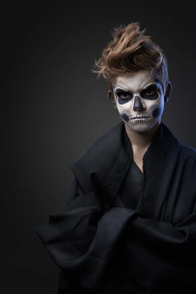 Teen with make-up of the skull in black cape