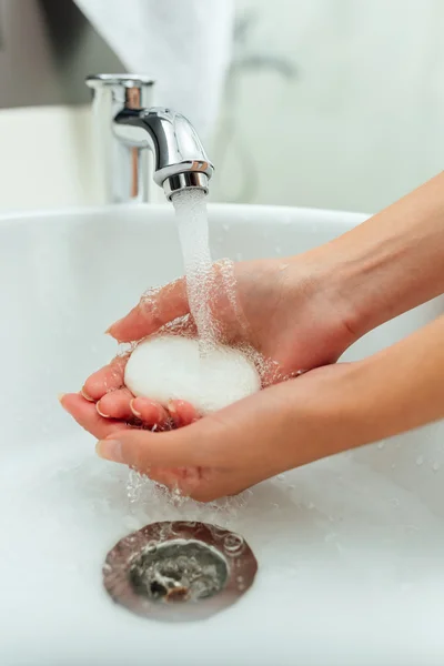 Woman washes her hands with soup