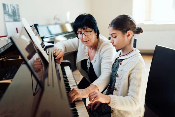 Music teacher shows how to play  piano