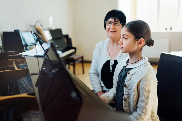 Piano lessons at  music school, teacher and student.