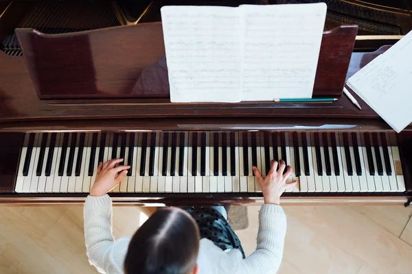 Girl playing  piano top view