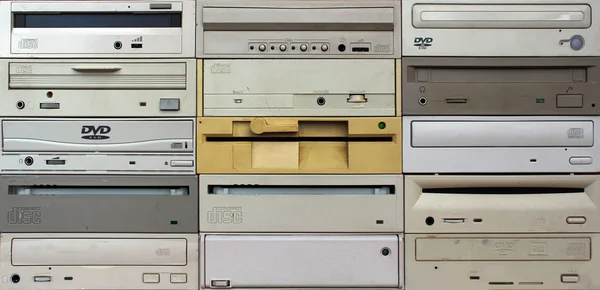 Front panels of old floppy cd and dvd drives as background