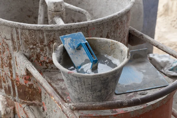 Trowel in cement bucket on concrete mixer machine