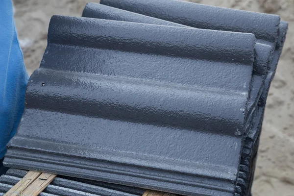 Stack of concrete roof tile (gray color) at construction site