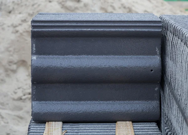 Stack of concrete roof tile (gray color) at construction site