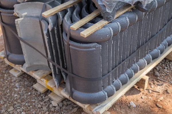 Stack of concrete roof tile (gray color) at construction site