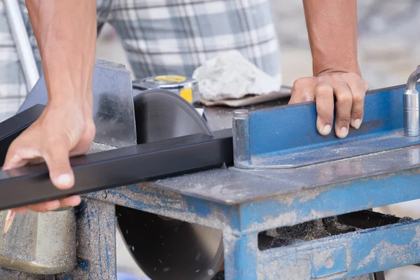 Worker cutting aluminium with grinder blade
