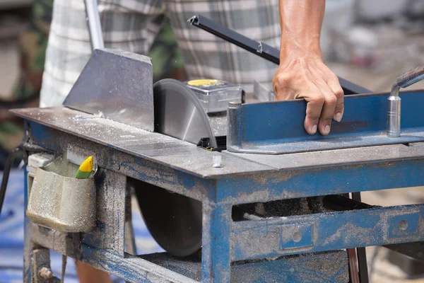 Worker cutting aluminium with grinder blade