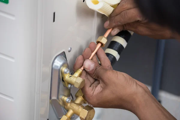 Installation of air conditioner, worker connects copper pipe