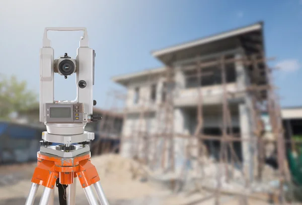 Survey equipment theodolite on a tripod. with building construct