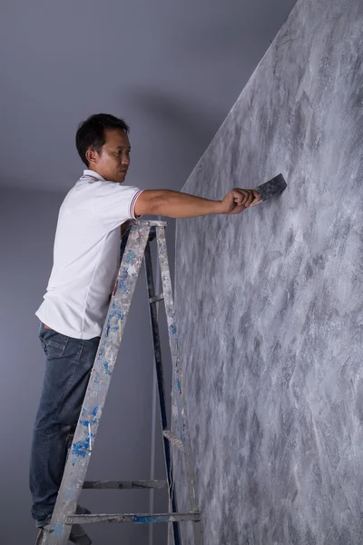 Worker use brush for color paint concrete Loft style on wall